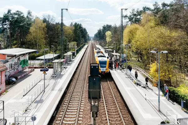 Menschen steigen an einem kleinen Potsdamer Bahnhof in einen Zug, um zu verreisen