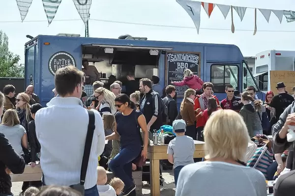 Menschen versammeln sich zum gemeinsamen Essen vor einem Foodtruck