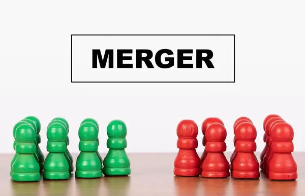 Merger concept with pawn figurines on table