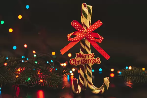Merry christmas background with lollipops cane on background of colorful garland bokeh