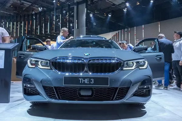 Messebesucher betrachten den Allradkombi BMW 330d xDrive mit Sechszylinderdiesel