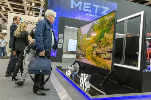 Messebesucher schauen auf den Sharp Fernseher 8K, mit riesigem 120" Bildschirm