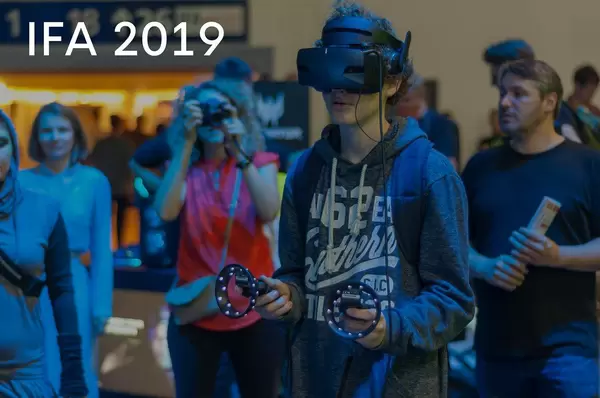 Messebesucher spielt Computerspiele mit VR-Brille, neben dem Bildtitel "IFA 2019"