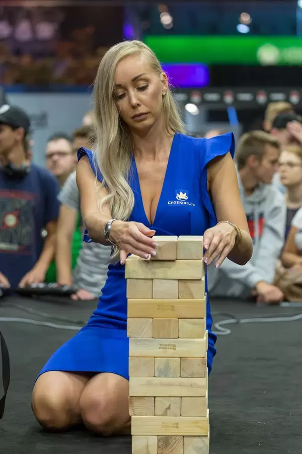 Messehostess bereitet einen Jenga-Turm am Caseking-Stand vor