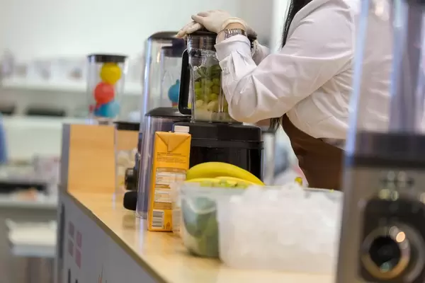 Messehostess verwendet einen Vakuum-Mixer von Kuvings