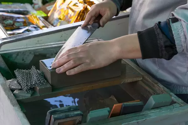 Messer wird auf Schleifstein geschliffen