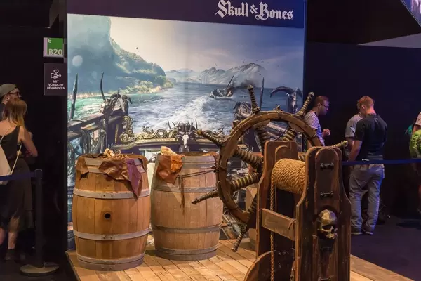 Messestand von Skull & Bones im Piraten-Look mit Rumfässern und Ruder