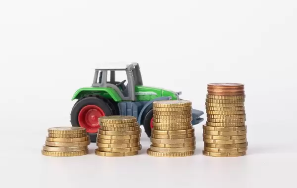 Metal coin stacks and tractor on white background