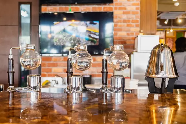 Metal kettle and brewing machines on glossy table (Flip 2019)