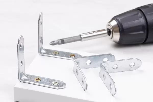 Metal Square corners for furniture with drill in the background