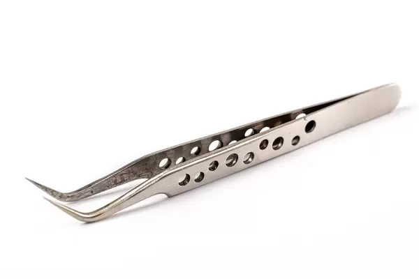 Metal tweezers on a white background