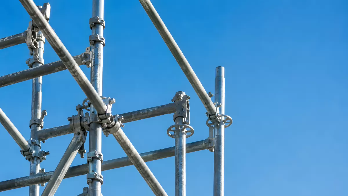 Metallgerüst mit Rohrverbindern vor blauem Himmel