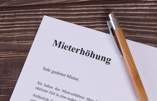 Mieterhöhung document with pen on wooden table