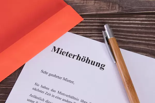 Mieterhöhung document with red envelope and pen
