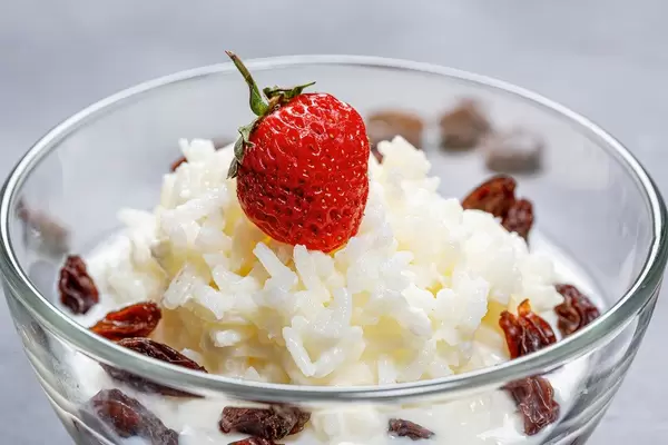 Milchreis mit Rosinen und eine Erdbeere close-up