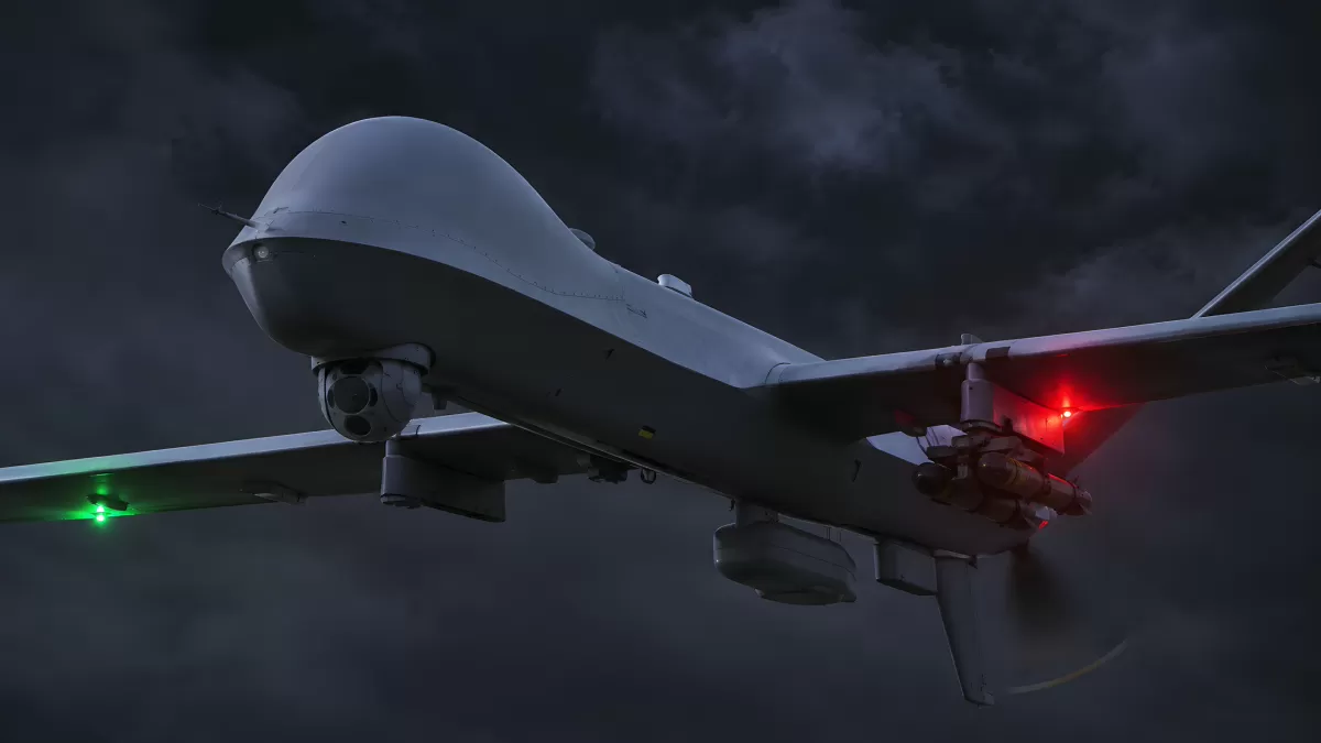 Militärdrohne fliegt nachts durch bewölkten Himmel
