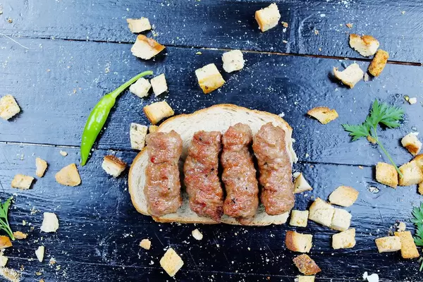 Minced meat rolls on a slice of bread