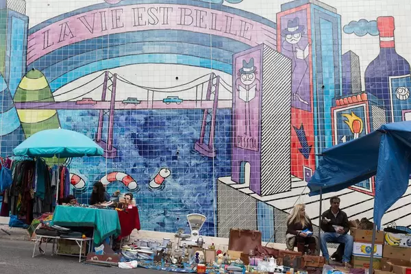 Mini-Flohmarkt mit Graffiti im Hintergrund in Lissabon, Portugal