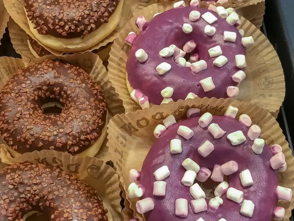 Mini-Marshmallow Donuts in lila und Schokoladendonuts in Papierformen