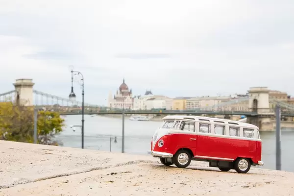 Mini red toy car in front of Chain Bridge in Budapest