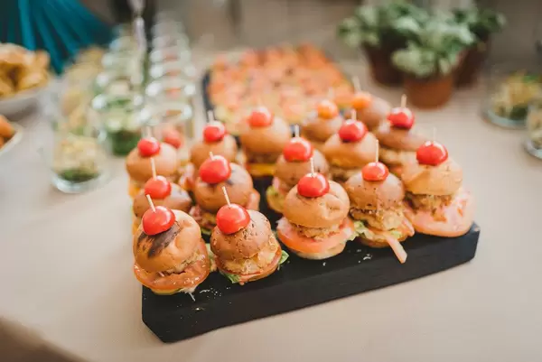 Miniatur-Burger auf einem schwarzen Holzbrett