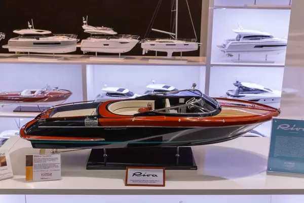 Miniatur eines eleganten Motorboots ausgestellt an Messe, im Hintergrund weitere Modellboote