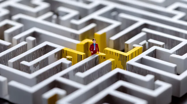 Miniatur-Geschäftsmann findet Lösung im Labyrinth