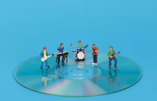 Miniature band standing on CD
