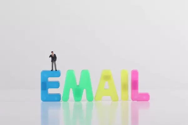 Miniature businessman with Email text on white background