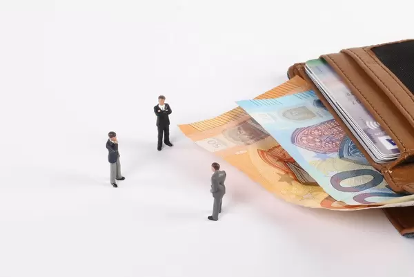 Miniature businessman with open wallet and Euro banknotes