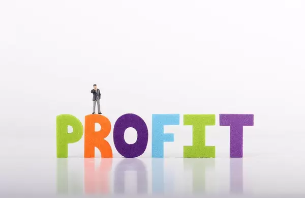 Miniature businessman with Profit text on white background