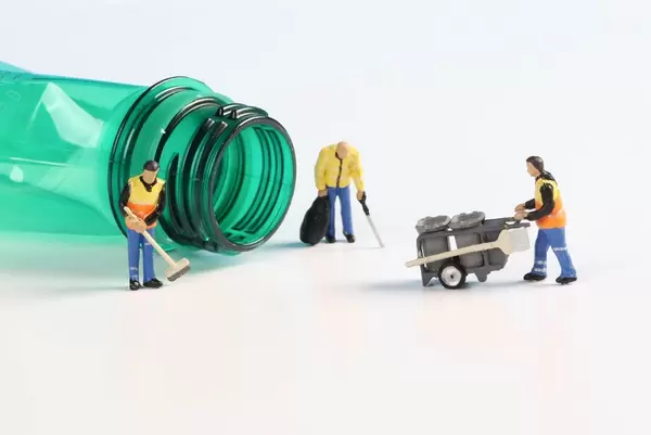 Miniature cleaning workers with empty plastic bottle
