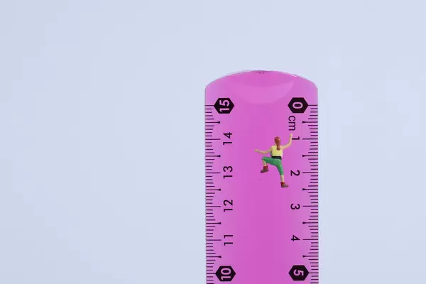 Miniature climber on school measuring ruler