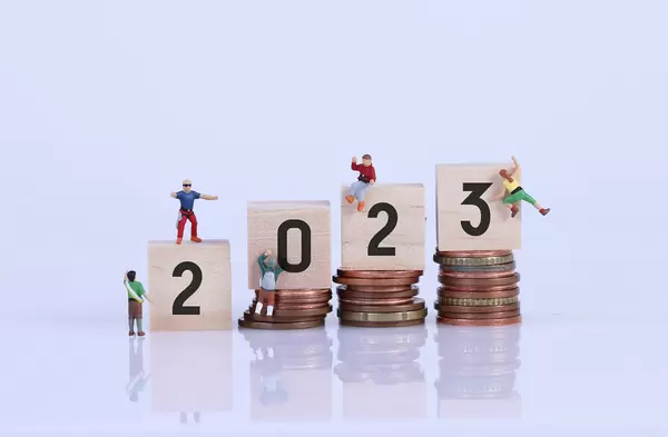 Miniature climber with coin stacks and wooden blocks with 2023 text