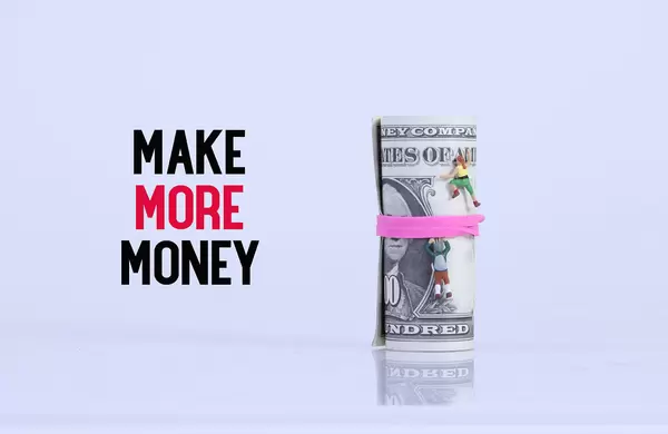 Miniature climbers on money roll and Make More Money text