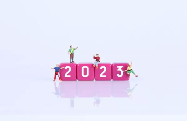 Miniature climbers on pink blocks with 2023 text on white background