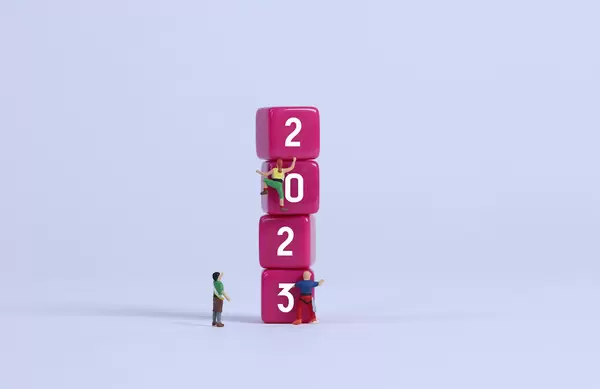 Miniature climbers on pink blocks with 2023 text