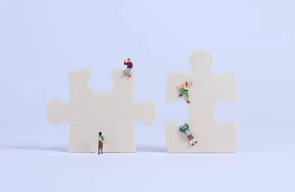 Miniature climbers on puzzle pieces