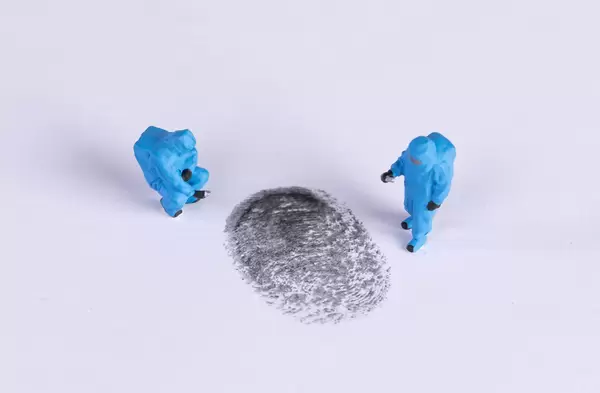 Miniature crime investigators with a finger print