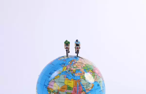 Miniature Figures Ride Bicycle on globe