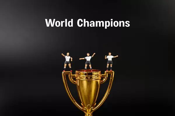 Miniature football players with golden trophy and World Champions text