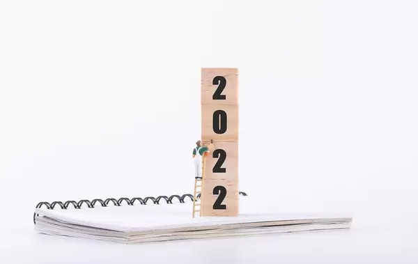 Miniature painter and wooden blocks with 2022 text on white background