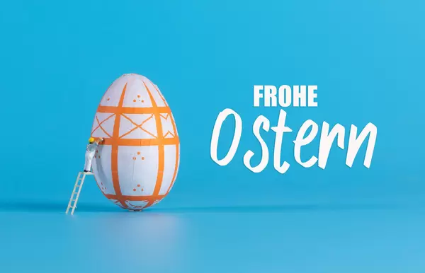 Miniature painter painting easter egg and Frohe Ostern text