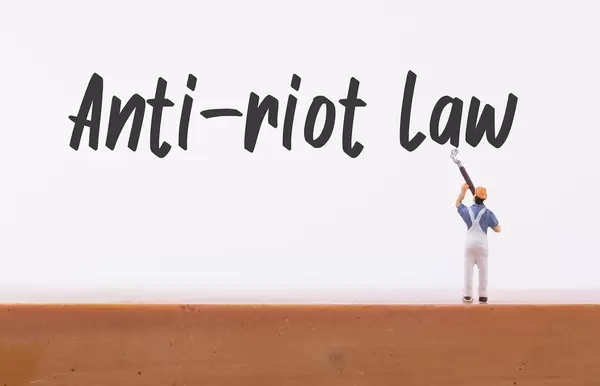 Miniature painter with Anti-riot Law text