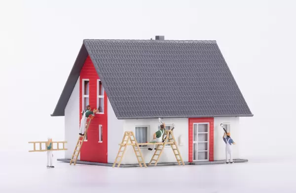 Miniature painters painting a house