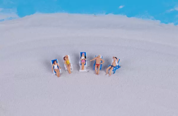Miniature people at sandy beach
