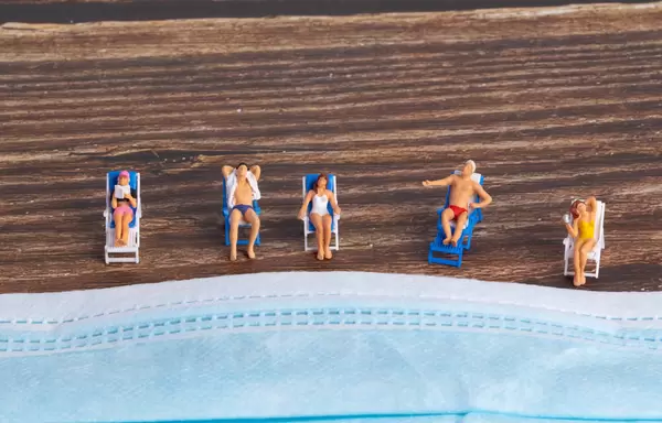 Miniature people relaxing near the face mask