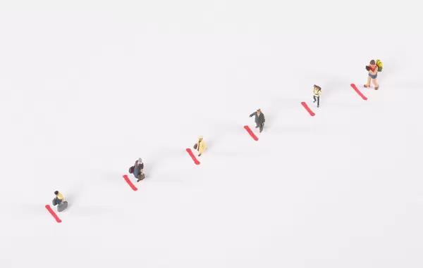 Miniature people standing in line