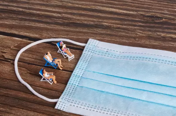 Miniature people sunbathing on the beach