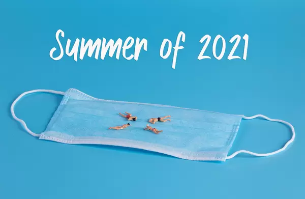 Miniature people swimming on medical face mask and Summer of 2021 text